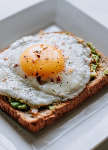 bread with sunny side-up egg served on white ceramic plate