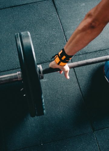 man holding black barbell